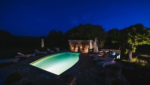 A swimming pool with lounge chairs and umbrellas, surrounded by stone walls and trees. - Stancia Vigini by Villas Guide (Grožnjan)
