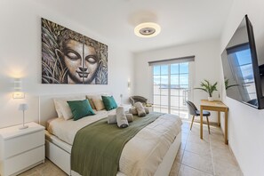 A modern bedroom with a large bed, a desk, and a large window. - Apartment with an Ocean View and a Summery Atmosphere (Playa de las Américas)