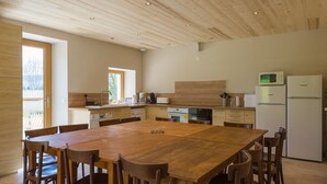 Een ruime keuken met houten keukenkastjes, een groot eiland en moderne apparatuur.