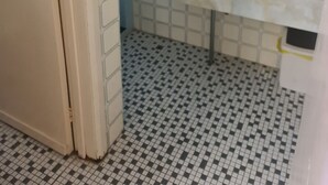 A bathroom with a tiled floor, a sink, and a mirror. - Cairns holiday unit apartment kitchen aircon wifi near esplanade and hospital (Cairns North)