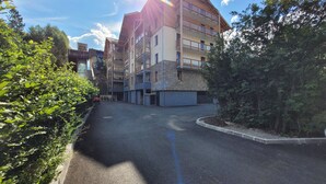 En fleretagers boligbygning med en stenfacade, altaner og en klar himmel.
