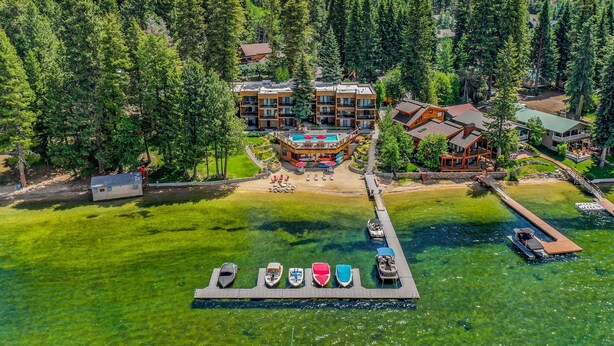 Ein Resort mit mehreren Gebäuden, einem Schwimmbad und einem Steg mit Booten.