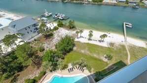 A pool with a view of a beach and marina. - Sailmakers Place 903 | Two-Story Penthouse | Panoramic Views | My Beach Getaways (Pensacola)