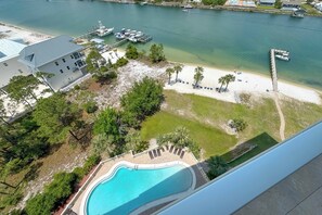 A pool with a view of a beach and marina. - Sailmakers Place 903 | Two-Story Penthouse | Panoramic Views | My Beach Getaways (Pensacola)
