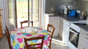 Een keuken met een eettafel, stoelen, een koffiezetapparaat en een vaatwasser.