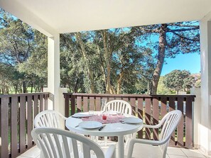 A round table with white chairs on a balcony with a view of trees and a clear sky. - Cabin studio near golf and ocean with wifi and secure parking (Moliets-et-Maa)