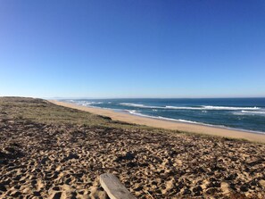 A beach with a wooden boardwalk leading to the ocean, sandy terrain, and a clear blue sky. - Cabin studio near golf and ocean with wifi and secure parking (Moliets-et-Maa)