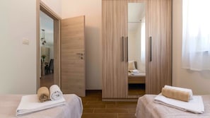 Ein Hotelzimmer mit zwei Betten, einem Schrank und einem Spiegel.