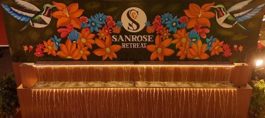 En vattendekoration med en logotyp och blommotiv på Sanrose Retreat.