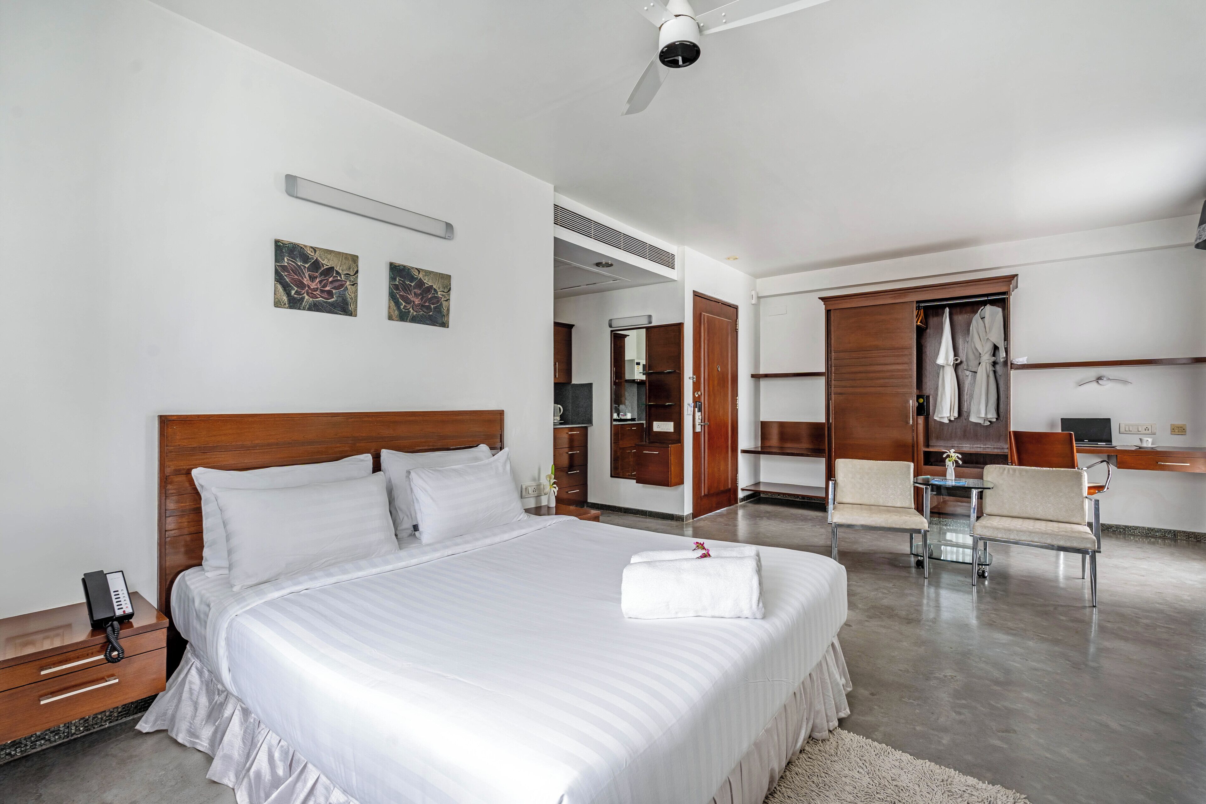 Une chambre d’hôtel moderne, dotée d’un grand lit, d’un bureau et d’une armoire.