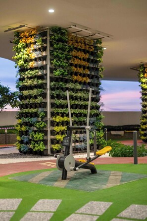 A vertical garden structure with a stationary exercise machine in the foreground. - (Kids Fun) 2BR Space Apt near KSL CIQ JB (Johor Bahru)