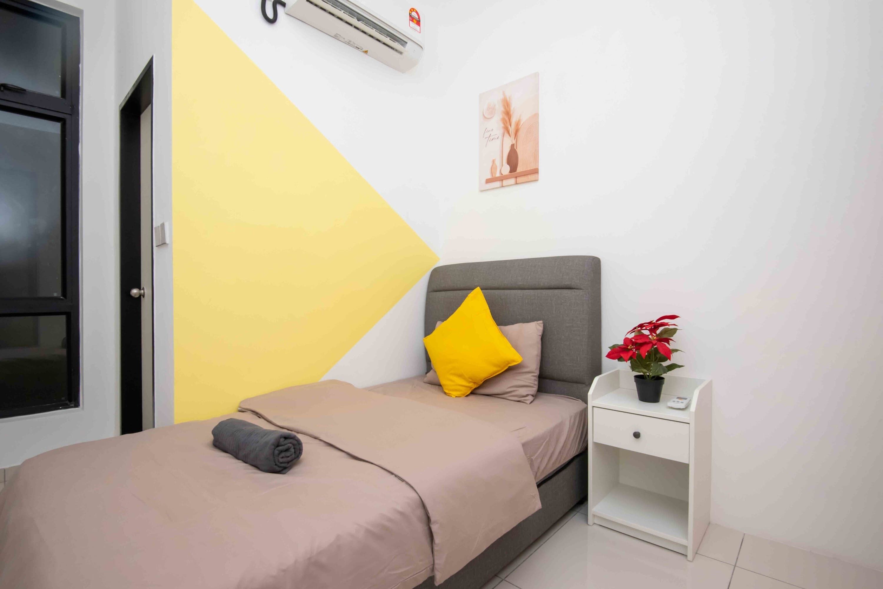 Un dormitorio con cama, mesita de noche, planta en maceta y aire acondicionado instalado en la pared.