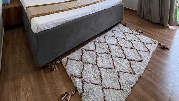 Une chambre moderne avec un grand lit, un ventilateur de plafond et une grande fenêtre avec des rideaux.