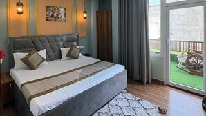 Une chambre avec un grand lit, un ventilateur de plafond et une vue sur l’extérieur.