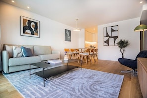 Uma sala de estar moderna com sofá, mesa de centro e área de jantar.
