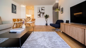 Un salon moderne comprenant un canapé, une table basse, un téléviseur et un coin repas.