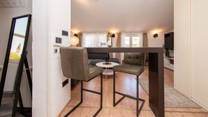 Ein gemütlicher Wohnbereich mit Essplatz, einer Couch und einem Fernseher.