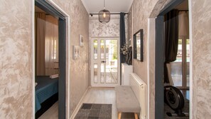 A narrow hallway with a bed, a radiator, a bench, and a treadmill. - Vila Above Medulin by Villas Guide (Medulin)
