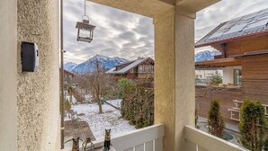 En balkon med udsigt over sneklædt terræn og bjerge.