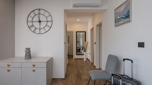 A hallway with a large wall clock, a small cabinet, a chair, and a painting. - Kuca za odmor Hana by Villas Guide (Vodnjan)