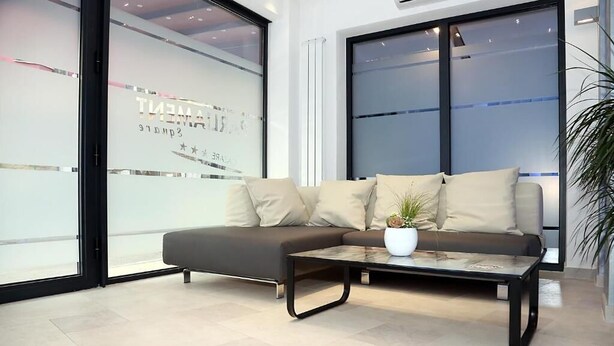 A modern living room with a sofa, a coffee table, and a potted plant.
