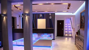 A modern interior with a central staircase, recessed lighting, and a minimalist design.