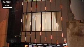 A modern building with a sign for 'Central Apartment Cazare'.