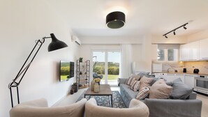 Un salon moderne avec un canapé, une table basse et une lampe.