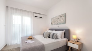 Un dormitorio con cama, mesita de noche, lámpara y aire acondicionado instalado en la pared.