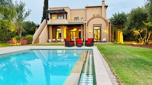 Una casa moderna con piscina, area relax esterna e giardino curato.