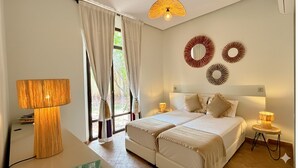 Una camera da letto con due letti, un'ampia finestra con tende e lampade a parete.