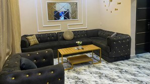 Una sala de estar moderna con un sofá modular, una mesa de centro y un reloj de pared decorativo.