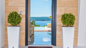 A modern hotel entrance with a clear view of a pool and the sea. - Villa Michelle with infinity pool (Maslenica)