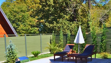 Una piscina al aire libre, sombrillas, sillones reclinables de piscina