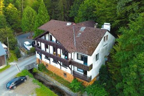 A two-story house with a sloped roof, a balcony, and a small attached shed. - Landgasthaus zur Hammermühle (Wallenfels)