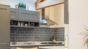 A modern kitchen with grey cabinets, a skylight, and a built-in stove. - Beautiful 2 Bedroom Barn in Cerney Wick (Cirencester)