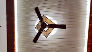 A ceiling fan with a central light fixture and a geometric design on the ceiling. - Radhe Palace (Ayodhya)