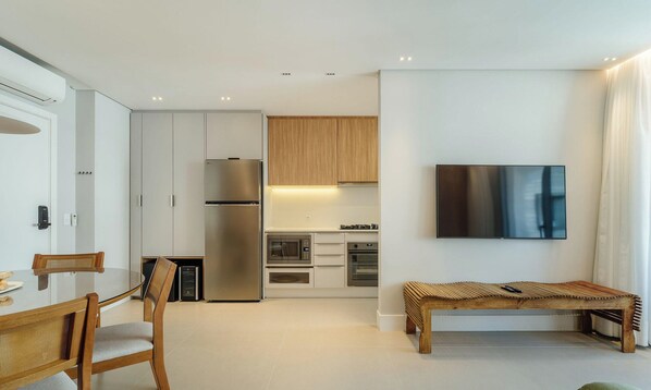 A modern kitchen with a built-in oven, microwave, and refrigerator. -  Apt w/ Barbecue Grill 50 m from the Beach DOI0203 (Florianópolis)