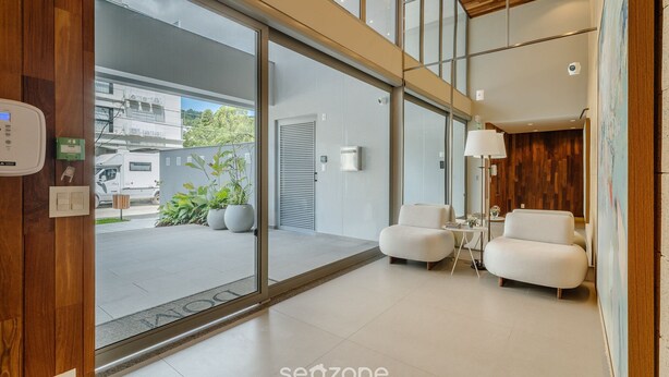 A modern interior with a reception area, a seating area, and a view of the street outside. -  Apt w/ Barbecue Grill 50 m from the Beach DOI0203 (Florianópolis)