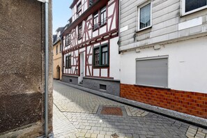 A narrow street with cobblestone pavement, a metal pole, and buildings with exposed timber framing and brickwork. - Guest House 'Apartment 3' with Shared Terrace (Braubach)