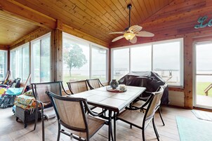 Un interior de madera con una mesa de comedor, sillas y un ventilador de techo.