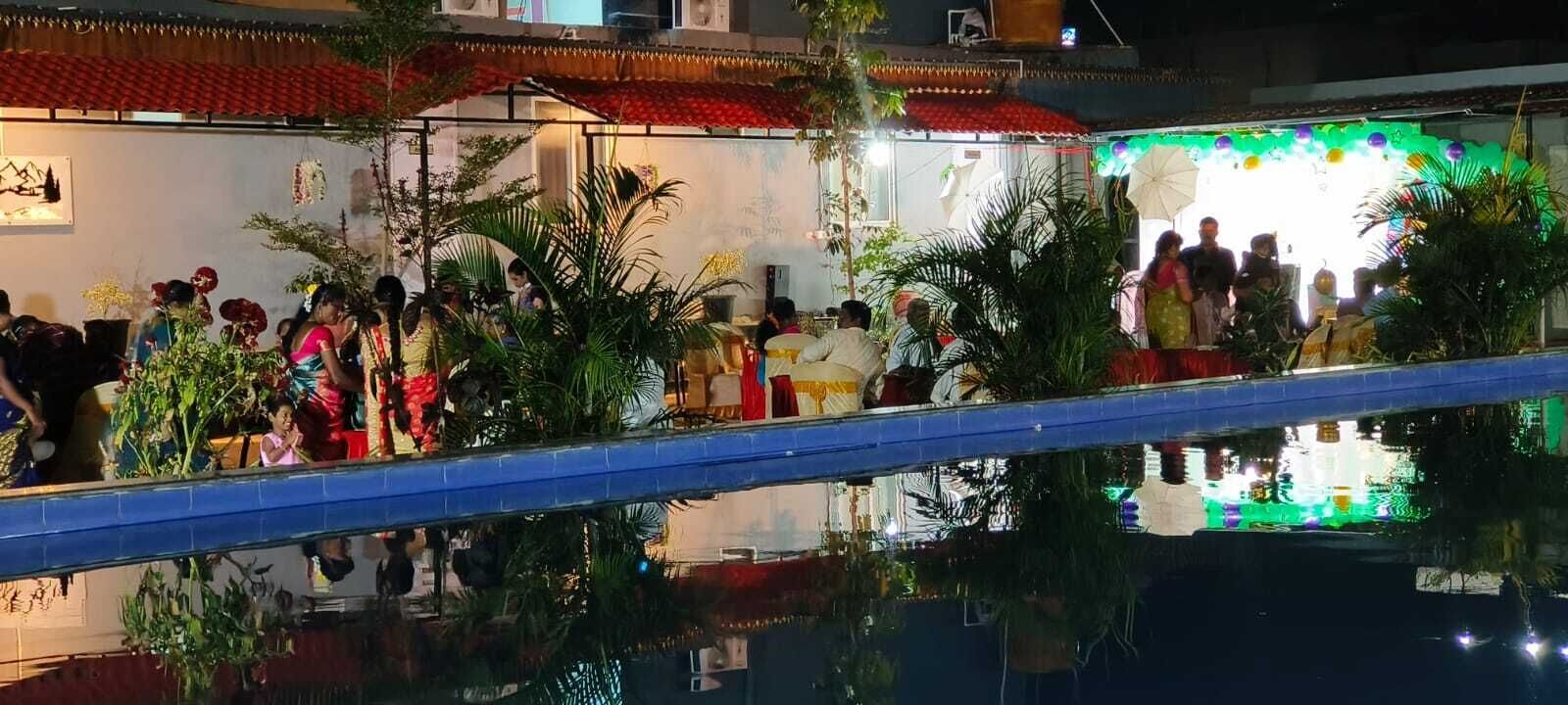 A group of people gathered at an outdoor event with a stage and decorations.