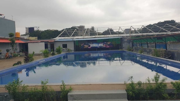 Une piscine dotée d’une structure de toit et ornée d’une fresque sur l’un de ses côtés.