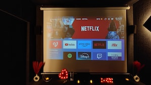 Un écran de projection affichant l’interface de Netflix, avec différentes icônes d’applications.