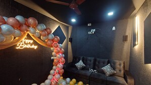 Une pièce avec un canapé, un ventilateur de plafond et un mur orné d’une pancarte sur laquelle on peut lire « Joyeux anniversaire ».