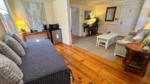 En hyggelig stue med sofa, kaffabar, spiseplads og køkken.