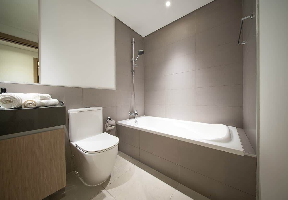 A modern bathroom with a toilet, a sink, and a bathtub.