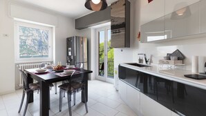 A modern kitchen with a dining area, large windows, and a view of the outdoors. - TERRACE ON LAKE ⭐️ ⭐️⭐️⭐️⭐️ Open Space & Netflix [Free Parking Area] (Lecco)