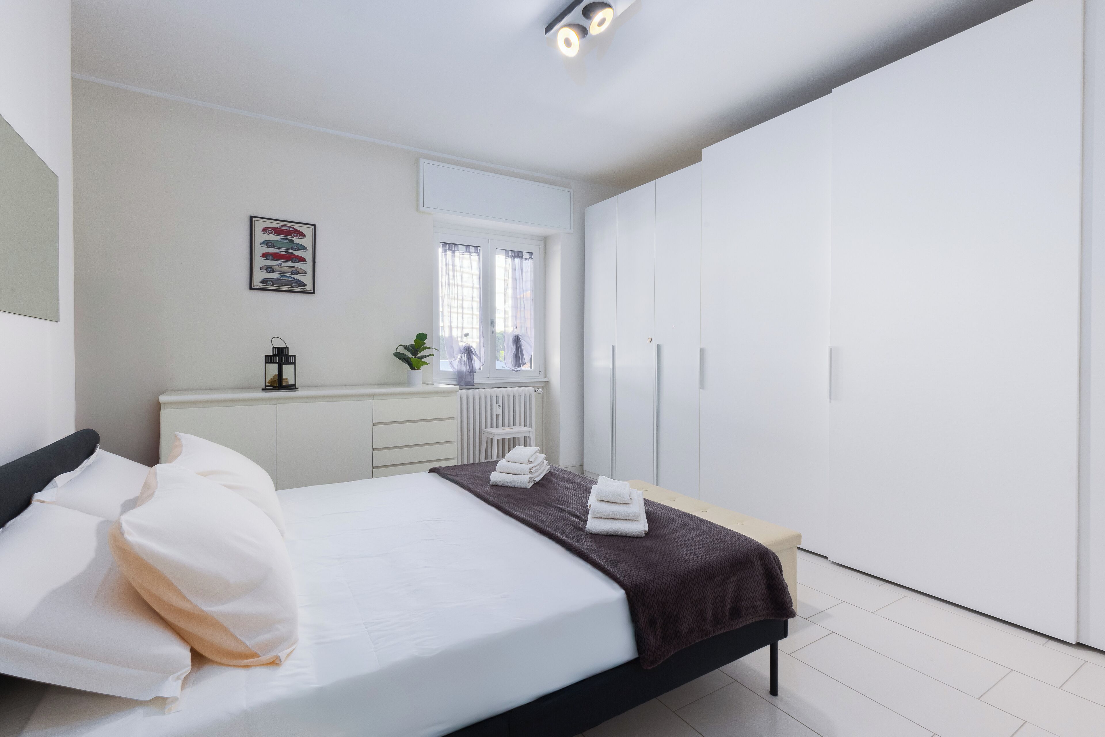 A modern bedroom with a bed, bedside table, and a wardrobe.