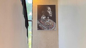 Een trap met een kunstwerk in een lijst aan de muur erboven.